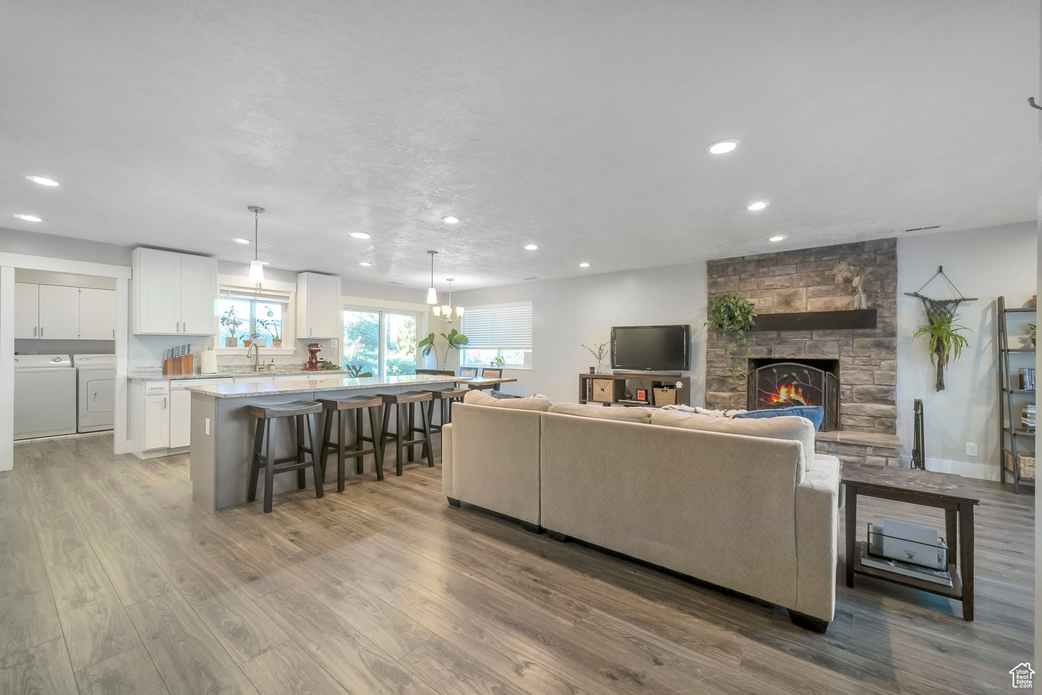 Living area featuring light wood finished floors, a fireplace, separate washer and dryer, and recessed lighting