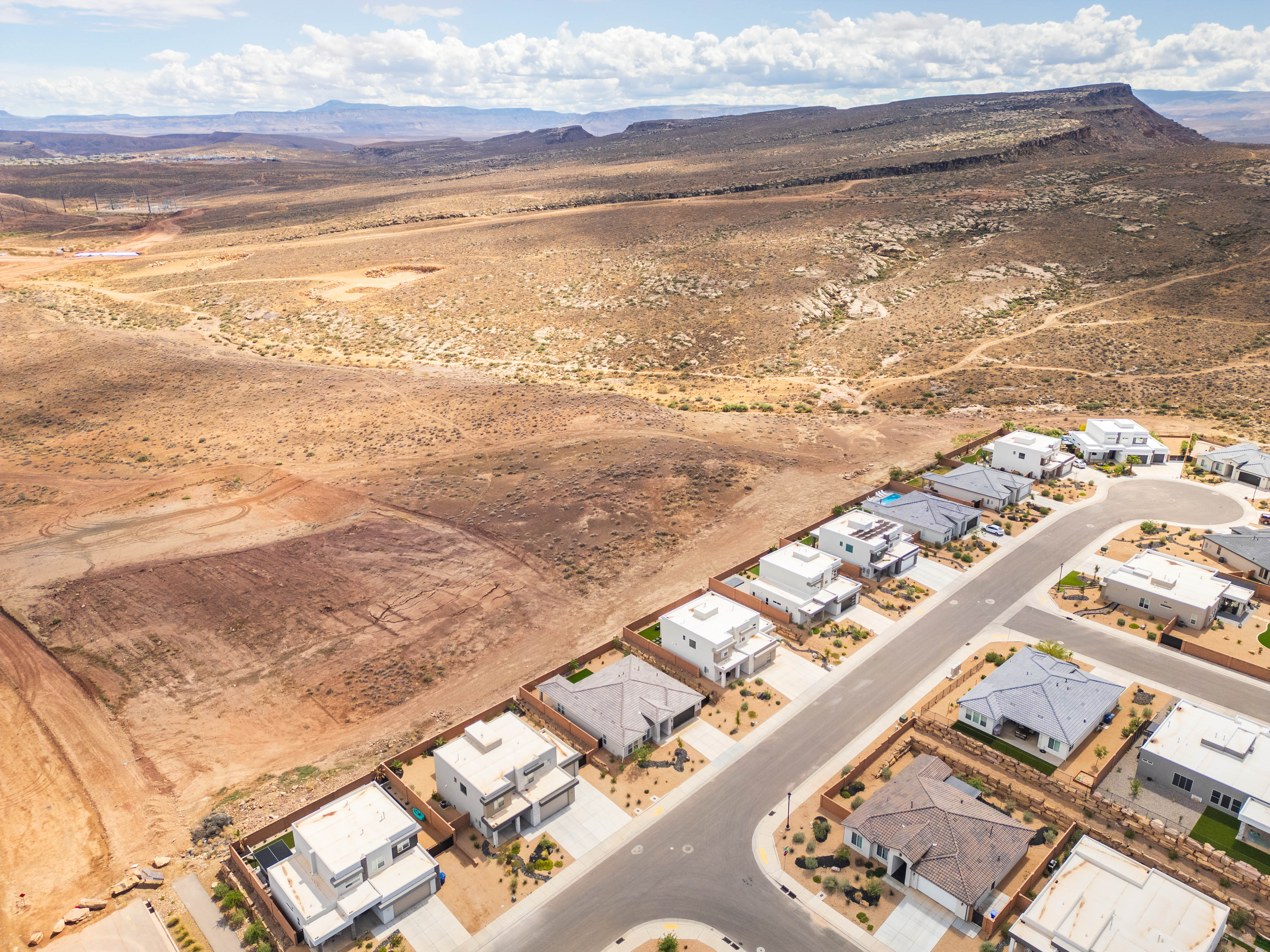 Aerial perspective of suburban area featuring a mountain backdrop and a desert landscape