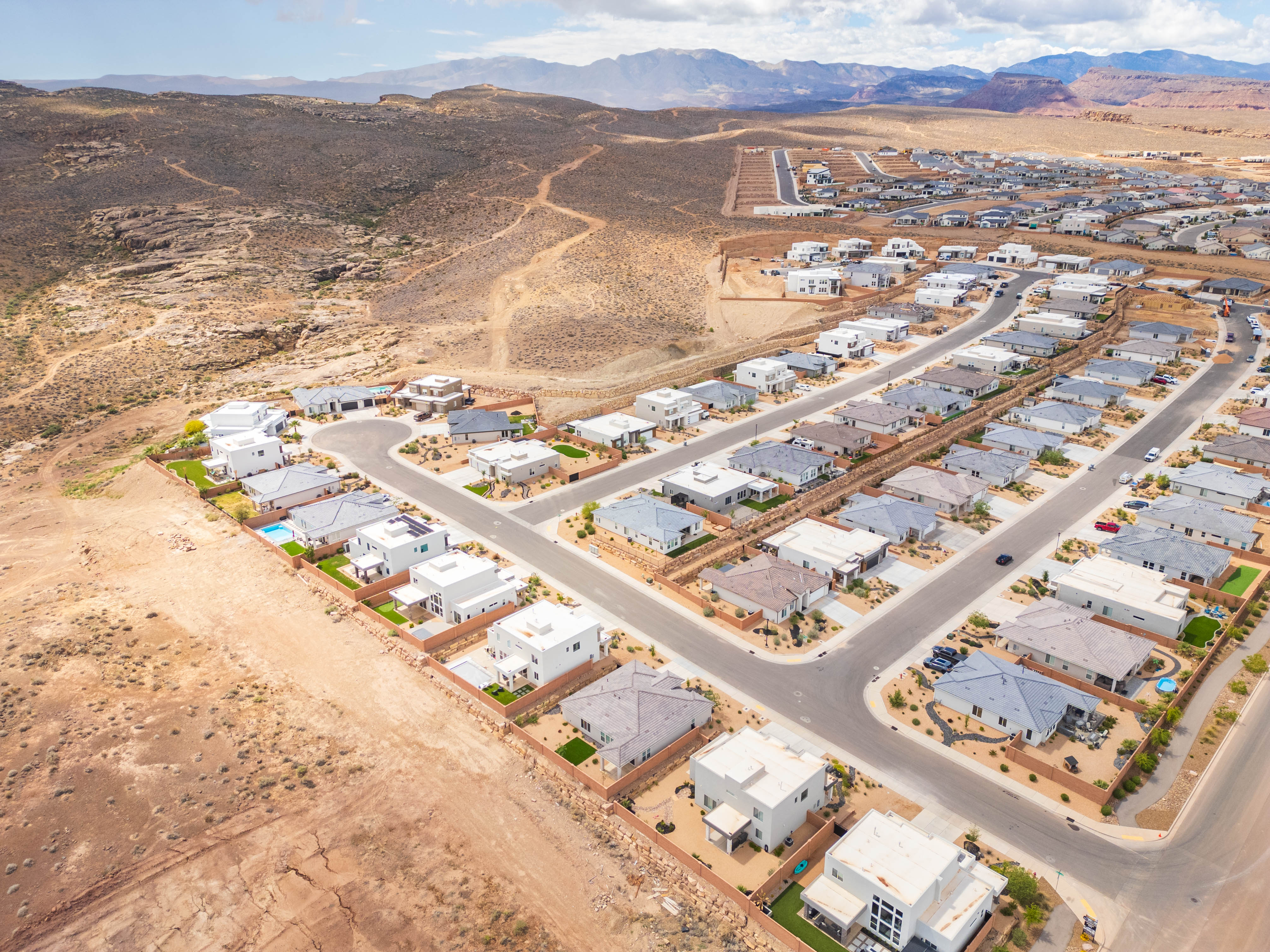 Aerial overview of property's location with nearby suburban area and a mountainous background