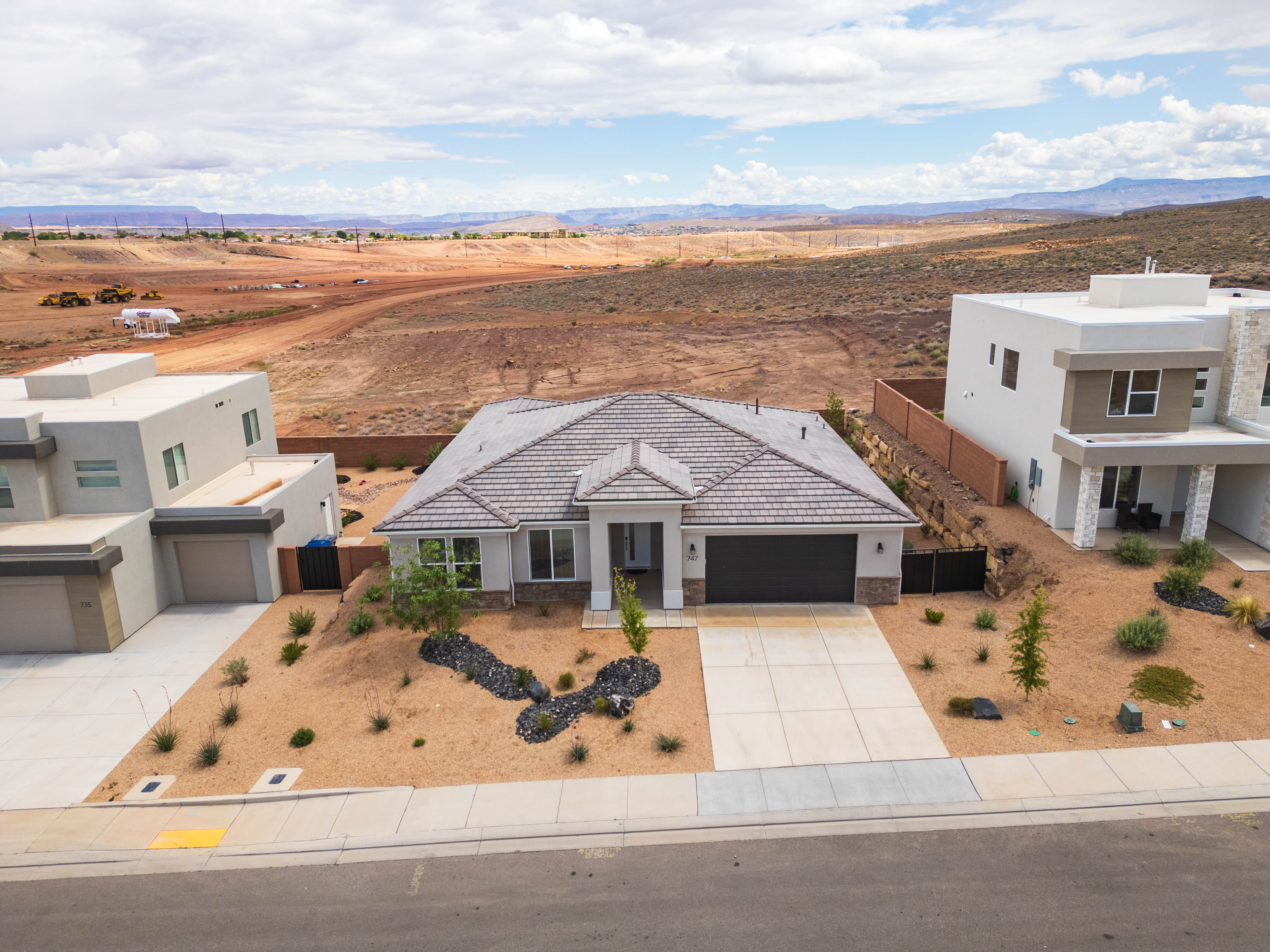 View of front of house with stucco siding, driveway, a garage, and stone siding