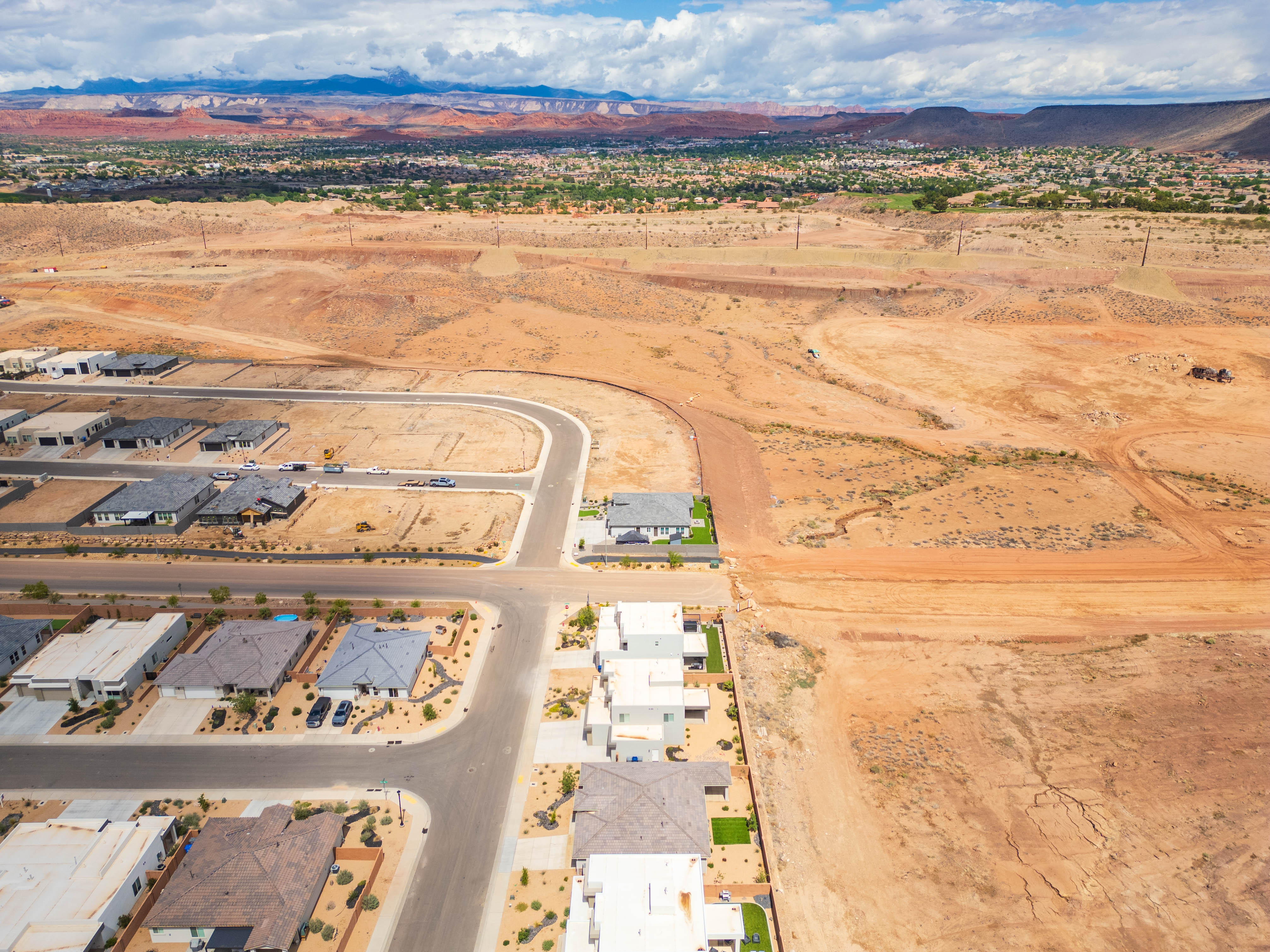 Aerial view of residential area featuring a mountainous background and a desert landscape