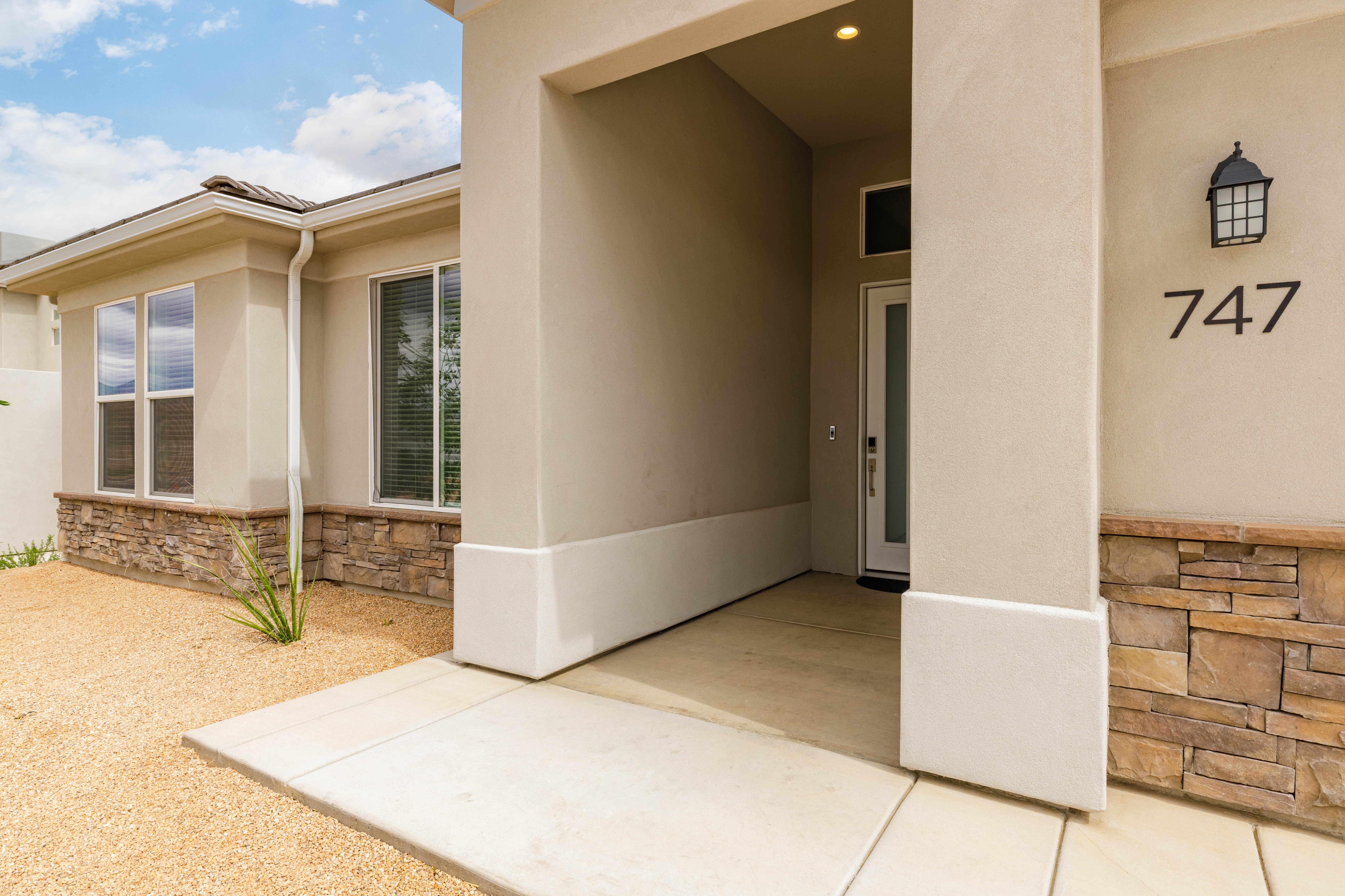 Doorway to property featuring stone siding and stucco siding