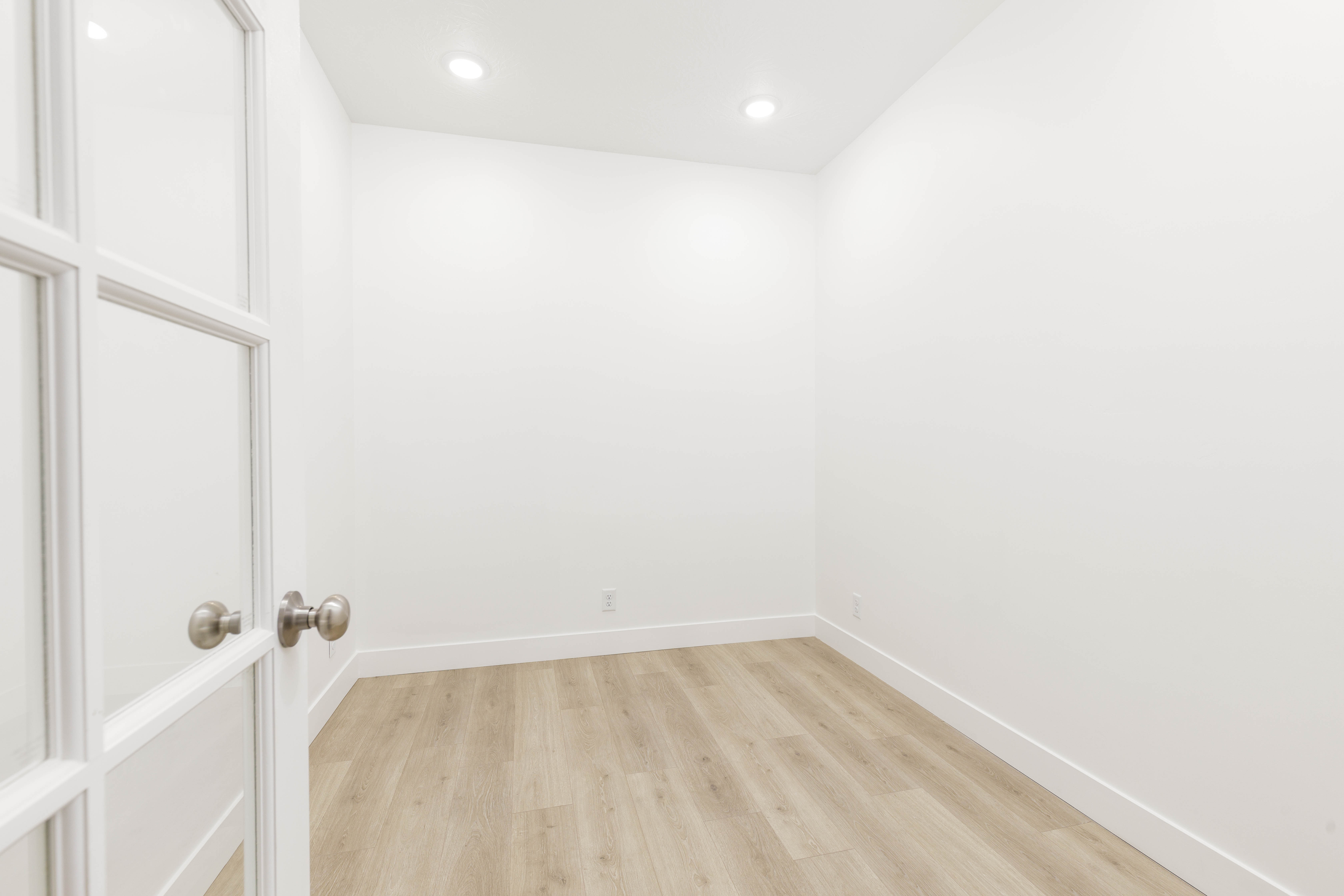Empty room featuring light wood-type flooring and recessed lighting