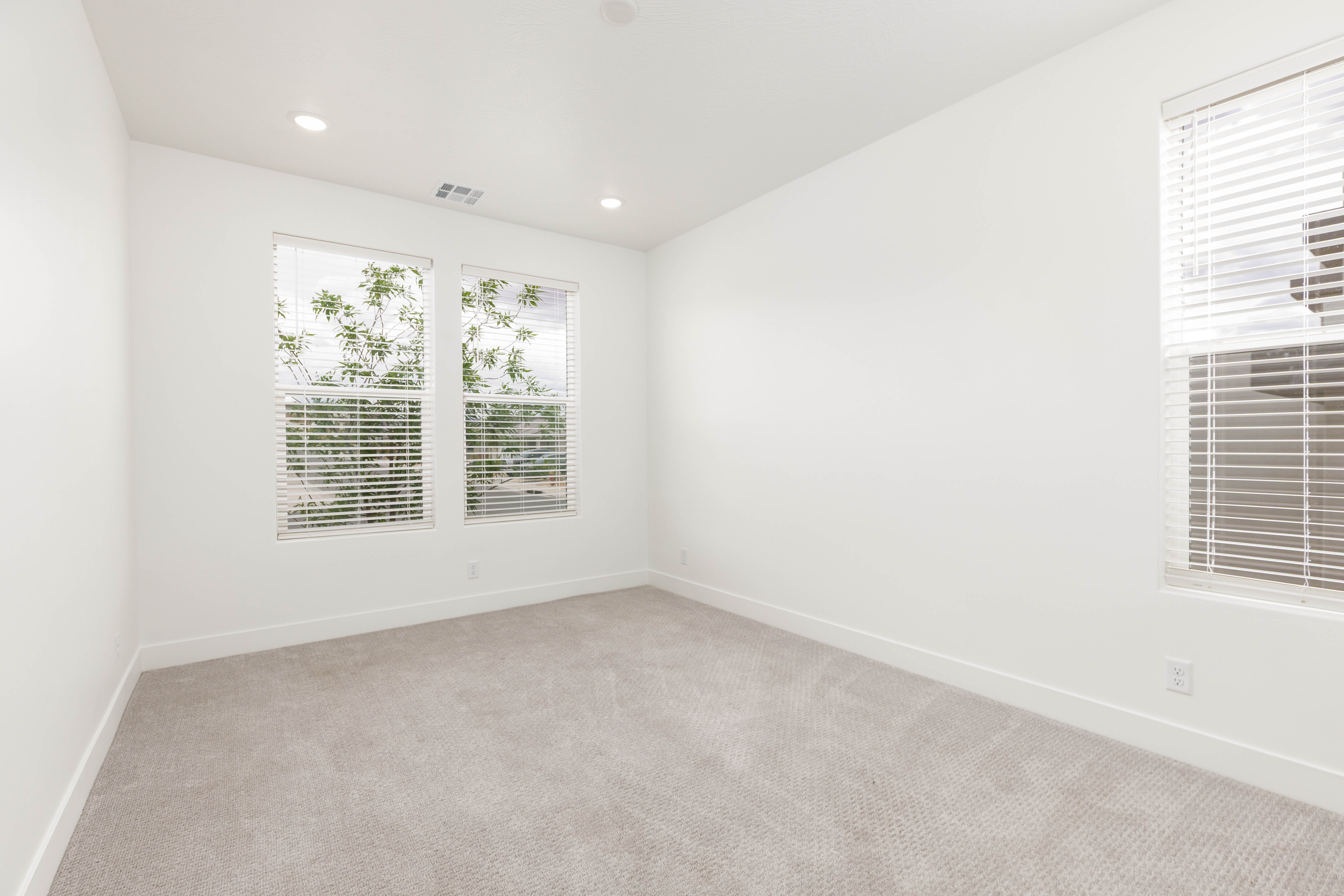 Carpeted empty room featuring baseboards and recessed lighting