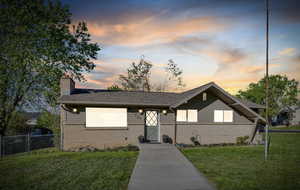 View of front of house with a chimney and brick siding