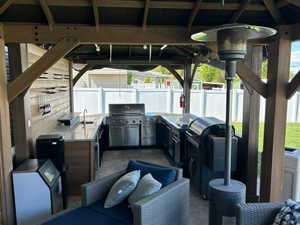 Fenced backyard featuring area for grilling, a gazebo, a patio area, and washer and clothes dryer