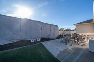 Fenced backyard with outdoor dining space and a patio area