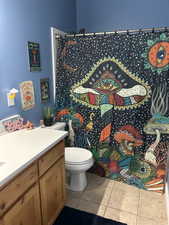 Full bathroom with a shower with shower curtain, vanity, and light tile patterned flooring