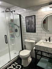 Full bathroom featuring tile walls and a stall shower