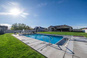 View of pool with patio surround, a diving board, and a fenced backyard