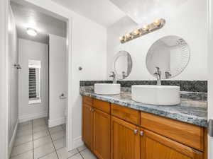 Basement bathroom with double vanity and shower.