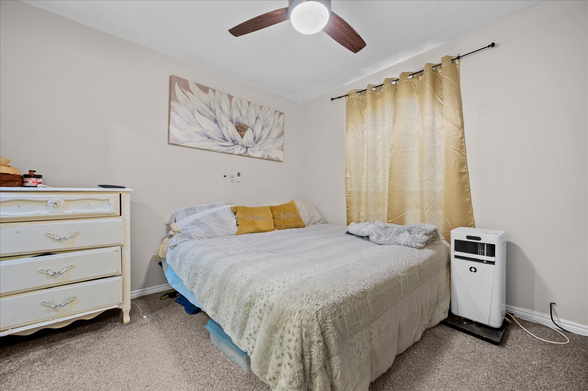 Bedroom with light carpet and a ceiling fan