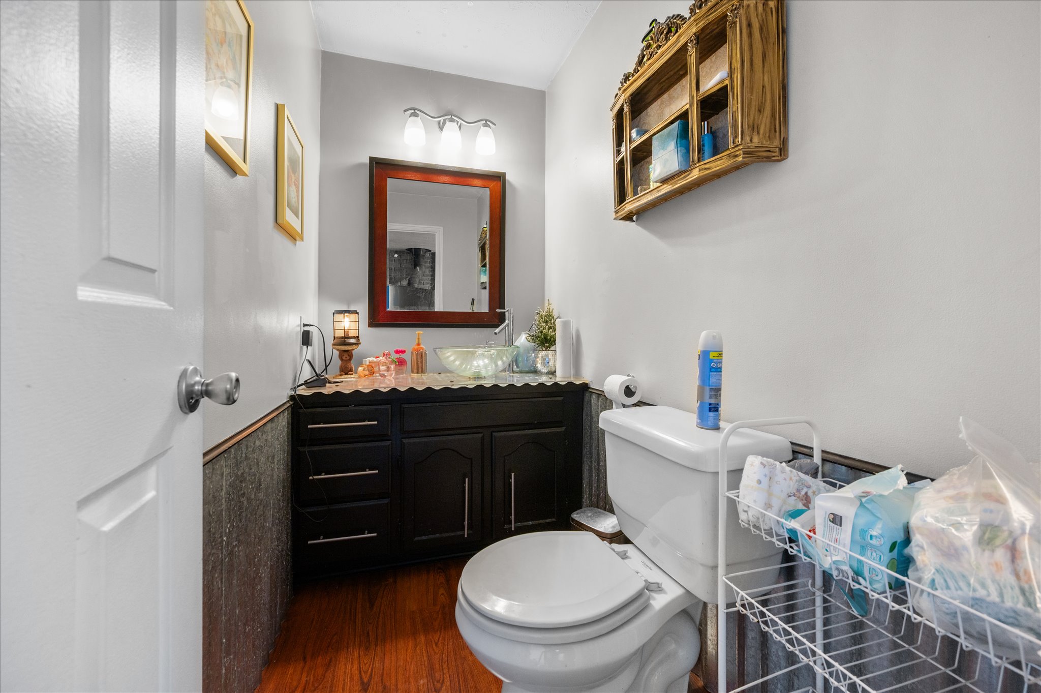 Half bathroom with vanity and dark wood-style flooring