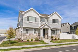 View of front facade with Hardie board siding, stone, and covered front porch