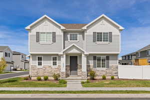 View of front facade with Hardie board siding, stone, and covered front porch