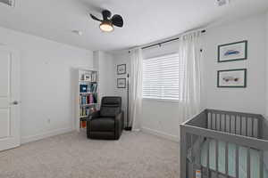 Bedroom featuring light carpet, bright natural light, single tone paint, and ceiling fan