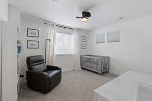 Bedroom featuring light carpet, bright natural light, single tone paint, and ceiling fan