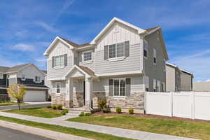 View of front facade with Hardie board siding, stone, and covered front porch