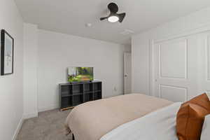 Second floor spare bedroom with carpet, floating shelving, and ceiling fan