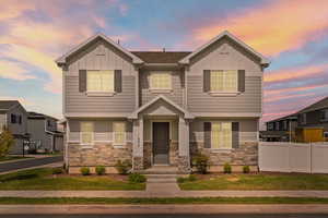 View of front facade with Hardie board siding, stone, and covered front porch