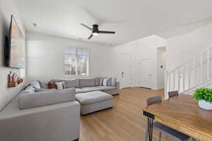 Open concept living room with high ceilings, LVP flooring, designer lighting, and natural light