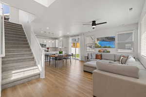 Open concept living room with high ceilings, LVP flooring, designer lighting, and natural light