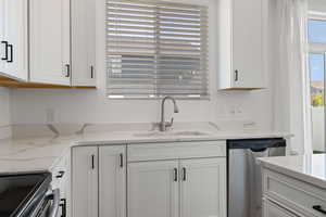 Kitchen with white cabinets, stainless steel appliances, and upgraded quartz counters
