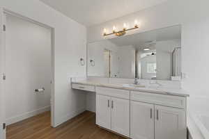 Primary ensuite bathroom featuring LVP flooring, vanity with white cabinets, upgraded quartz countertops, and makeup counter, separate soaker tub and shower