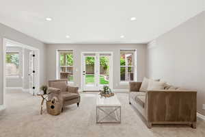 Living room with light colored carpet and recessed lighting