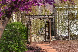 Gate featuring a pergola and a patio area