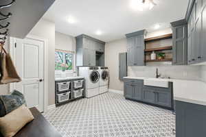 Laundry area with light flooring, washing machine and dryer, and cabinet space