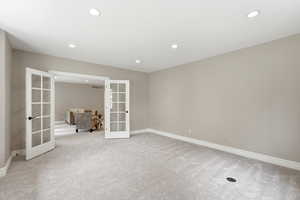 Spare room with french doors, light colored carpet, and recessed lighting