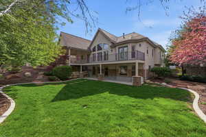 Back of property featuring stucco siding, stone siding, a patio area, a balcony, and roof with shingles