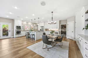 Dining space featuring hanging lights, healthy amount of natural light, and light wood-style flooring