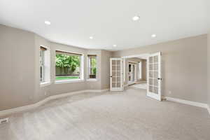 Unfurnished room with french doors, recessed lighting, and light colored carpet