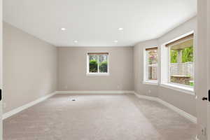 Empty room featuring light colored carpet and recessed lighting