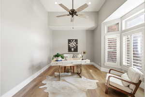 Office featuring a high ceiling, light wood finished floors, ceiling fan, and recessed lighting