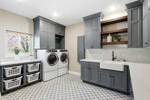 Laundry room with independent washer and dryer, cabinet space, and light flooring