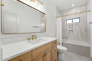 Full bath featuring vanity, tiled shower / bath, light tile patterned floors, and recessed lighting