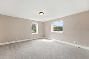 Carpeted empty room featuring healthy amount of natural light