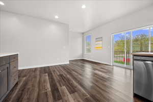 Unfurnished living room featuring recessed lighting and dark wood-style flooring