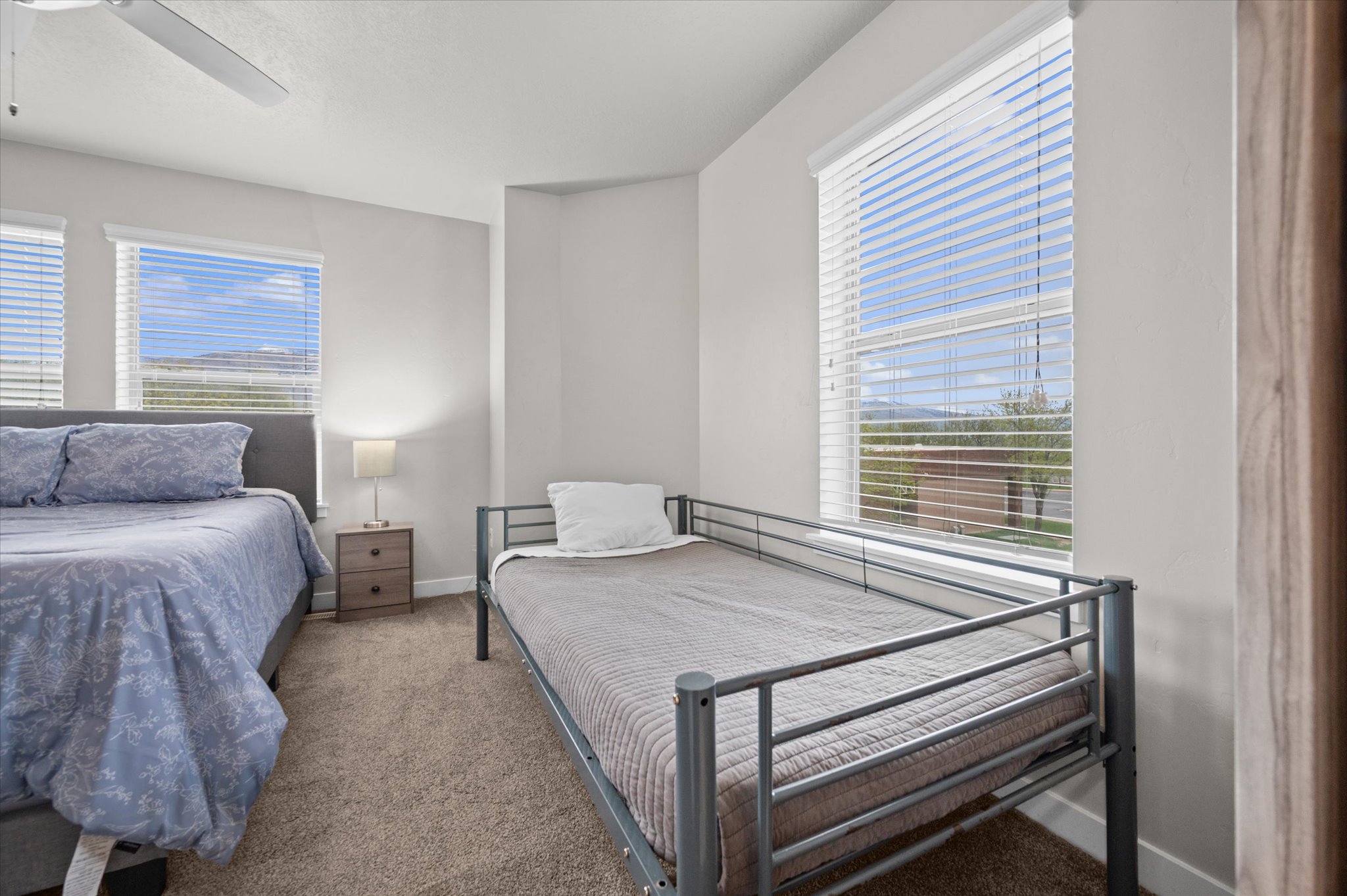 Carpeted bedroom with a ceiling fan and baseboards