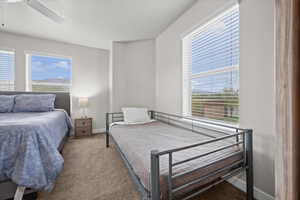 Carpeted bedroom with a ceiling fan and baseboards
