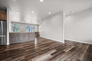 Unfurnished living room with recessed lighting and dark wood-style floors