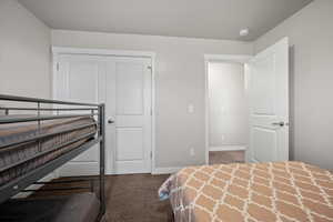 Bedroom featuring dark carpet and a closet