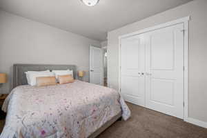 Bedroom featuring dark carpet and a closet