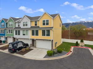 View of front of home with board and batten siding, concrete driveway, a garage, a mountain view, and a residential view
