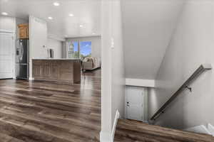 Stairway featuring wood finished floors and recessed lighting