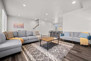 Living area with dark wood-style flooring and recessed lighting