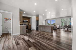 Kitchen with open floor plan, stainless steel appliances, light countertops, a peninsula, and recessed lighting